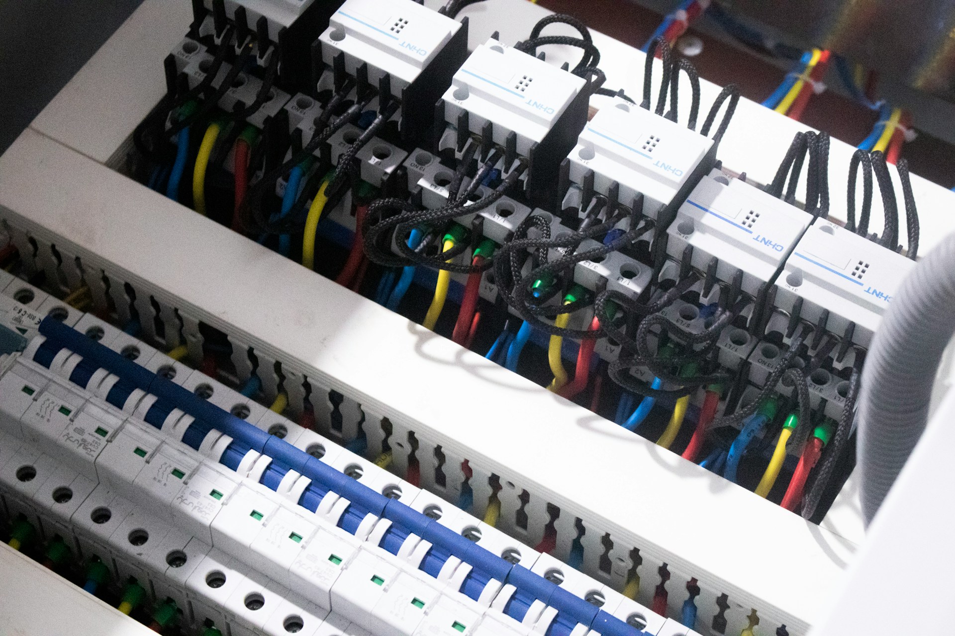 A distribution board with rows of circuit breakers mounted in the communal hallway of a residential block