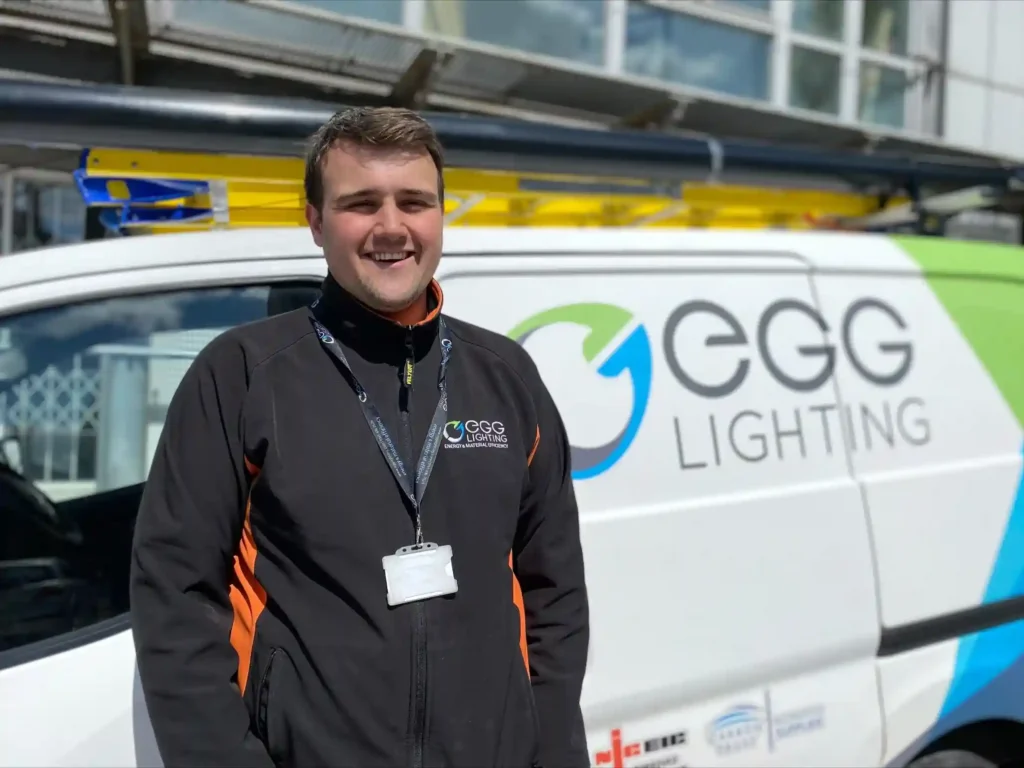 Electrician standing in front of an EGG Lighting van and the office building.